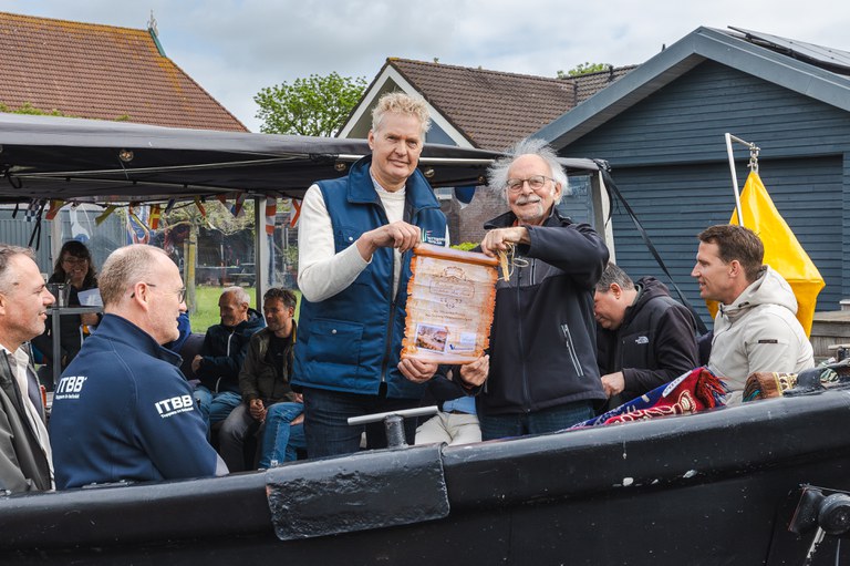 Dagelijks bestuurslid Gerben de Boer van Wetterskip Fryslân (links) en voorzitter Bertus Mulder van Stichting Waterschapserfgoed (rechts) met het overdrachtsdocument van sluis Broek. Foto: Aron Weidenaar.